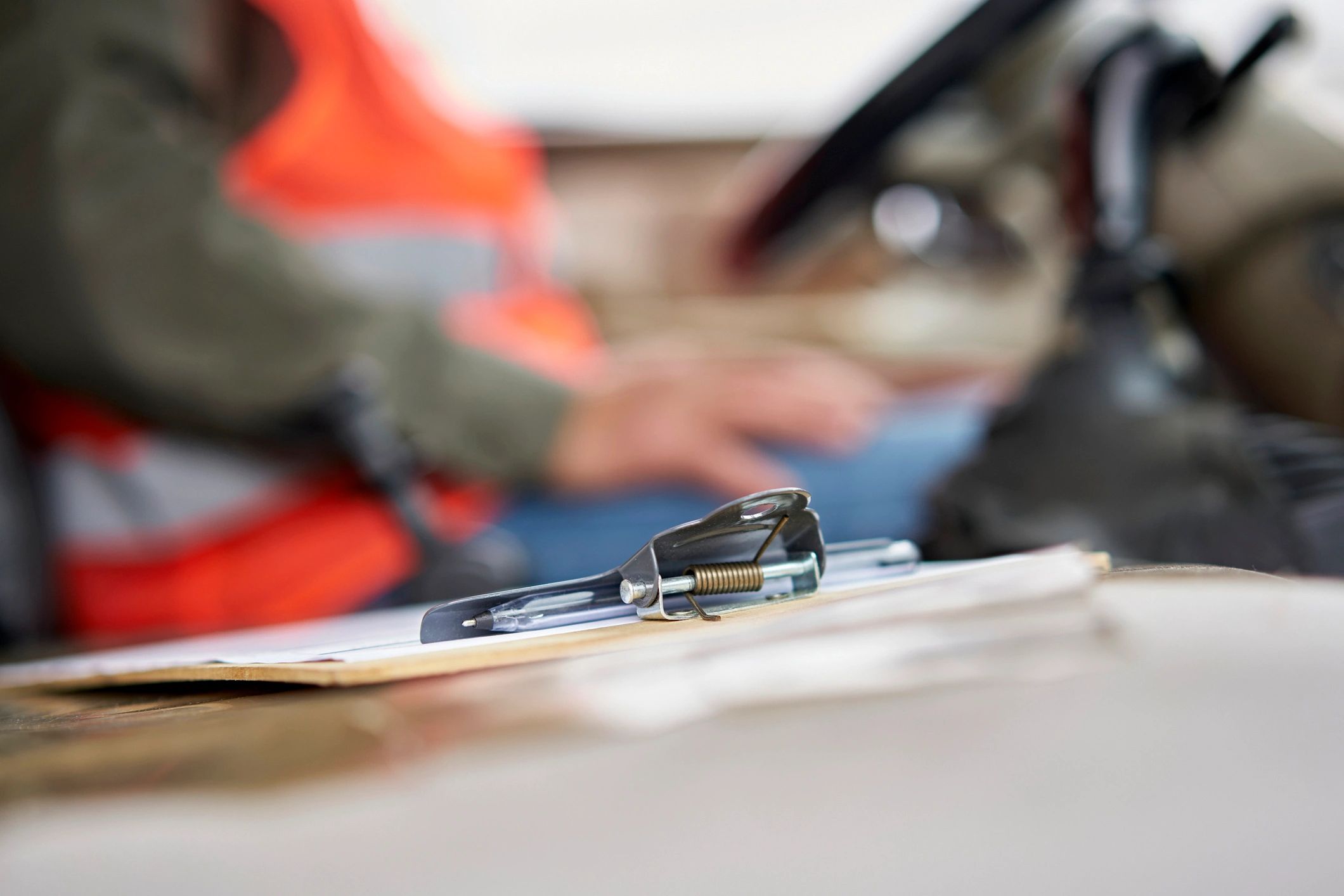 Clipboard with paperwork in a vehicle with worker in reflective vest
