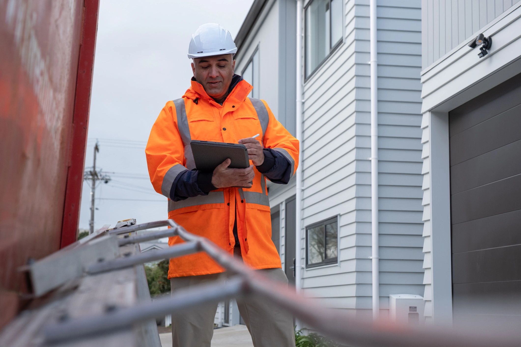 Site manager reviewing inspection notes on a tablet at a construction site